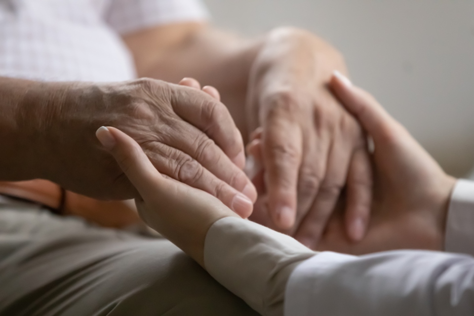 Hands of an elderly person joined with a young one